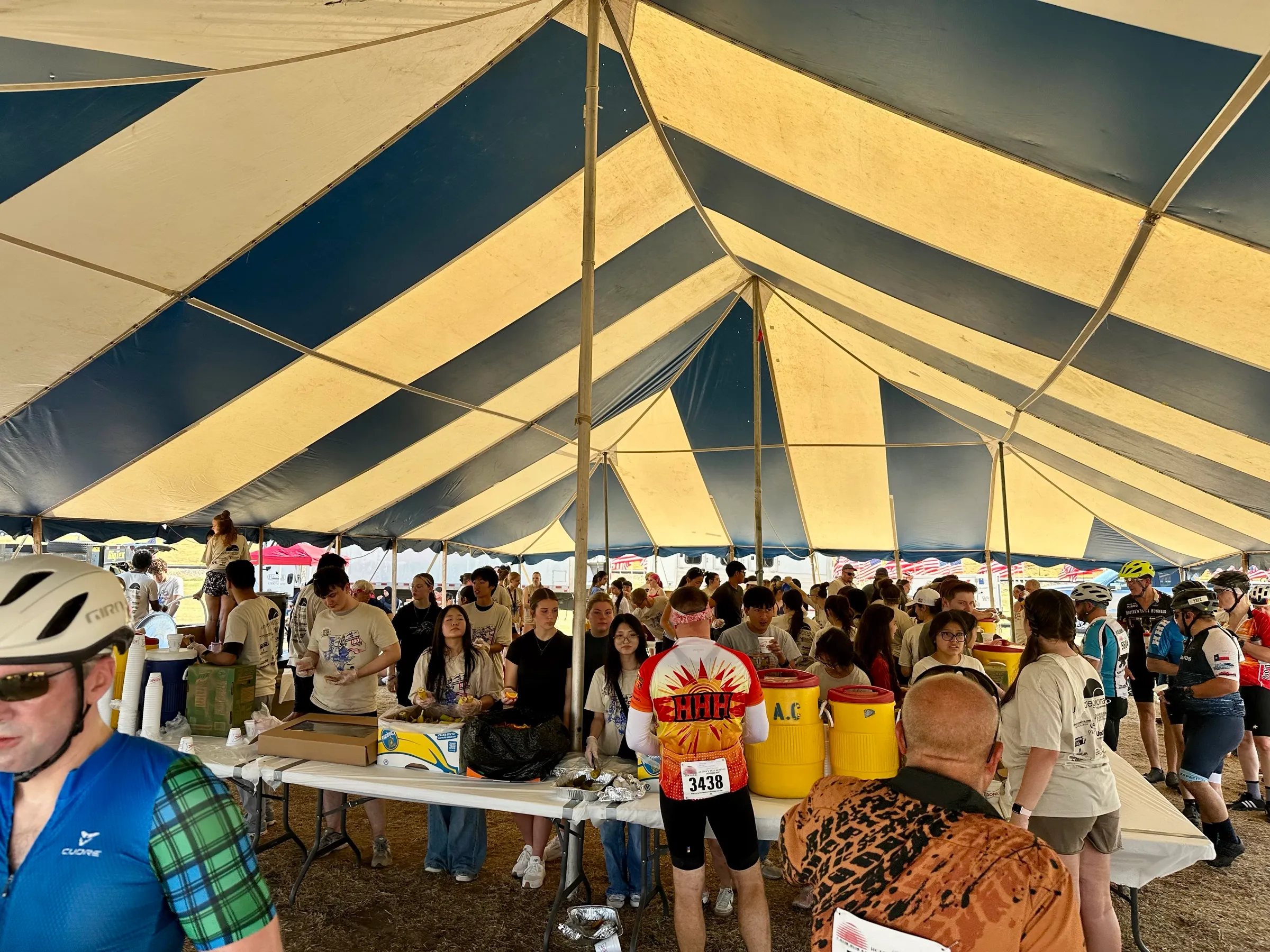 Hotter’N Hell Hundred riders gather under a shade canopy for food and refreshments.